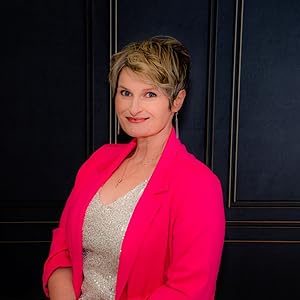 TL Johnson Author of Romantic Suspense in hot pink blazer against dark panel backdrop